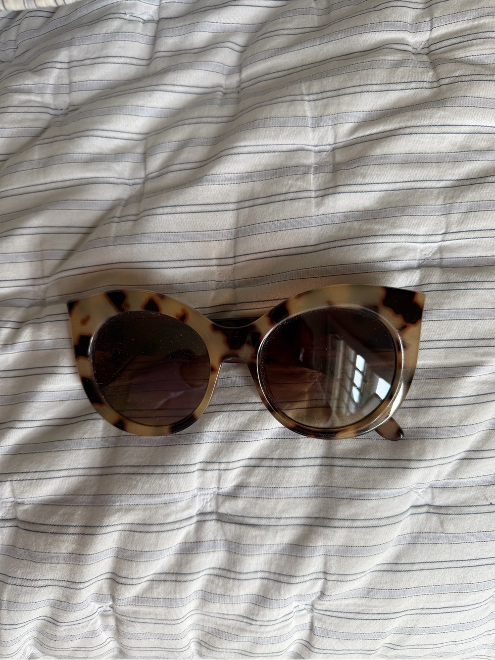 Brown and tan tortoiseshell cat-eye sunglasses.